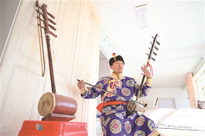 内蒙古自治区通辽市开鲁县脱贫户包莲在弹奏四弦胡琴.